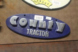 A painted oval sign for "County Tractor" (202)