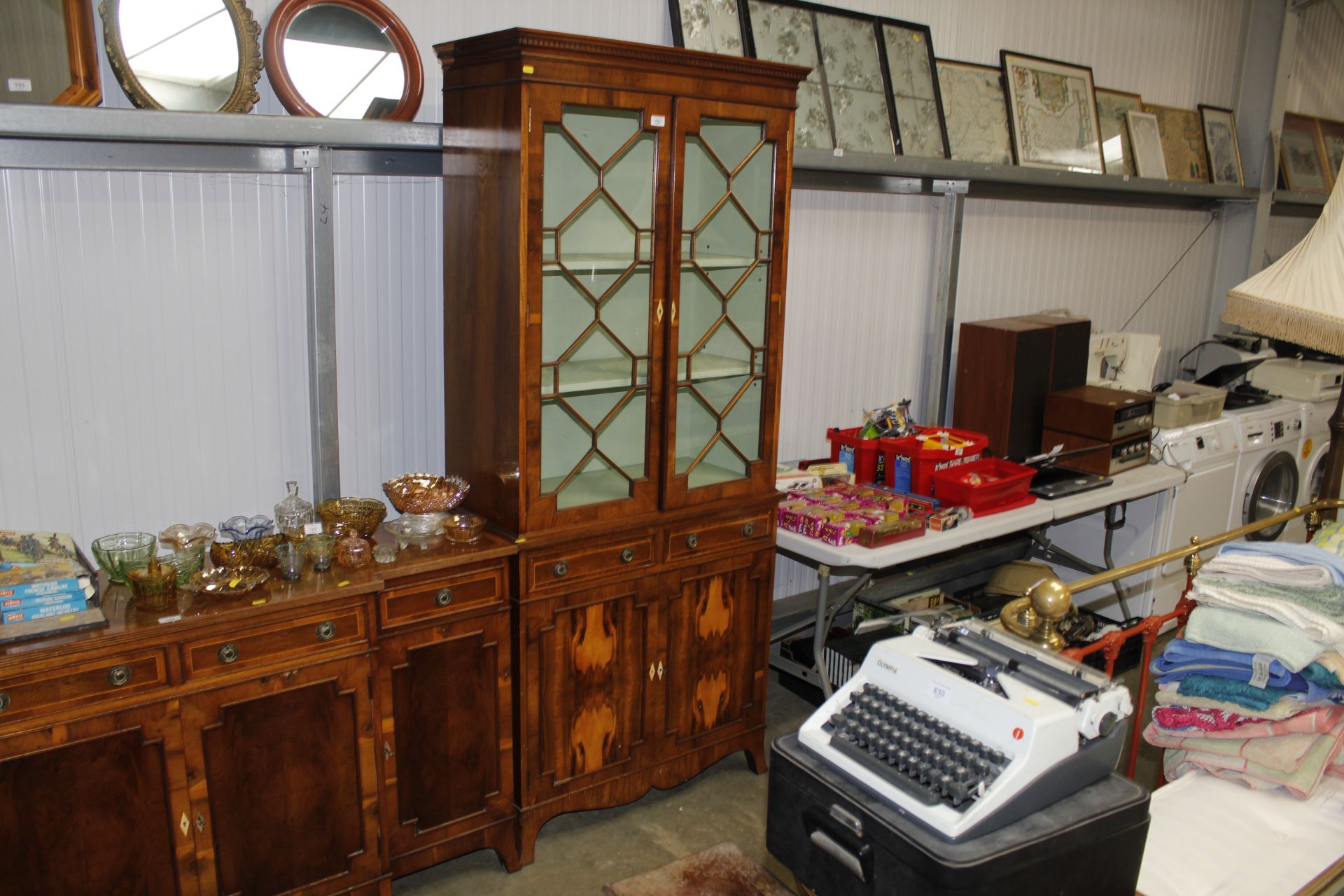 A yew wood half glazed display cabinet supported b