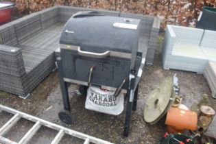 A Landmann charcoal BBQ with cover and bag of Mara