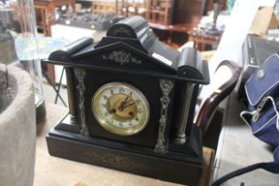 A late Victorian black slate two hole mantel clock