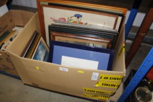 A box containing various pictures and prints inclu