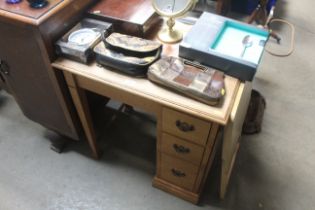 An oak and leather topped writing desk of small pr