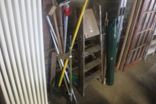 A quantity of long handled tools to include rakes,