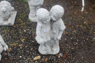A cast concrete garden statue in the form of two y