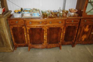 A yew wood sideboard fitted four short drawers ove