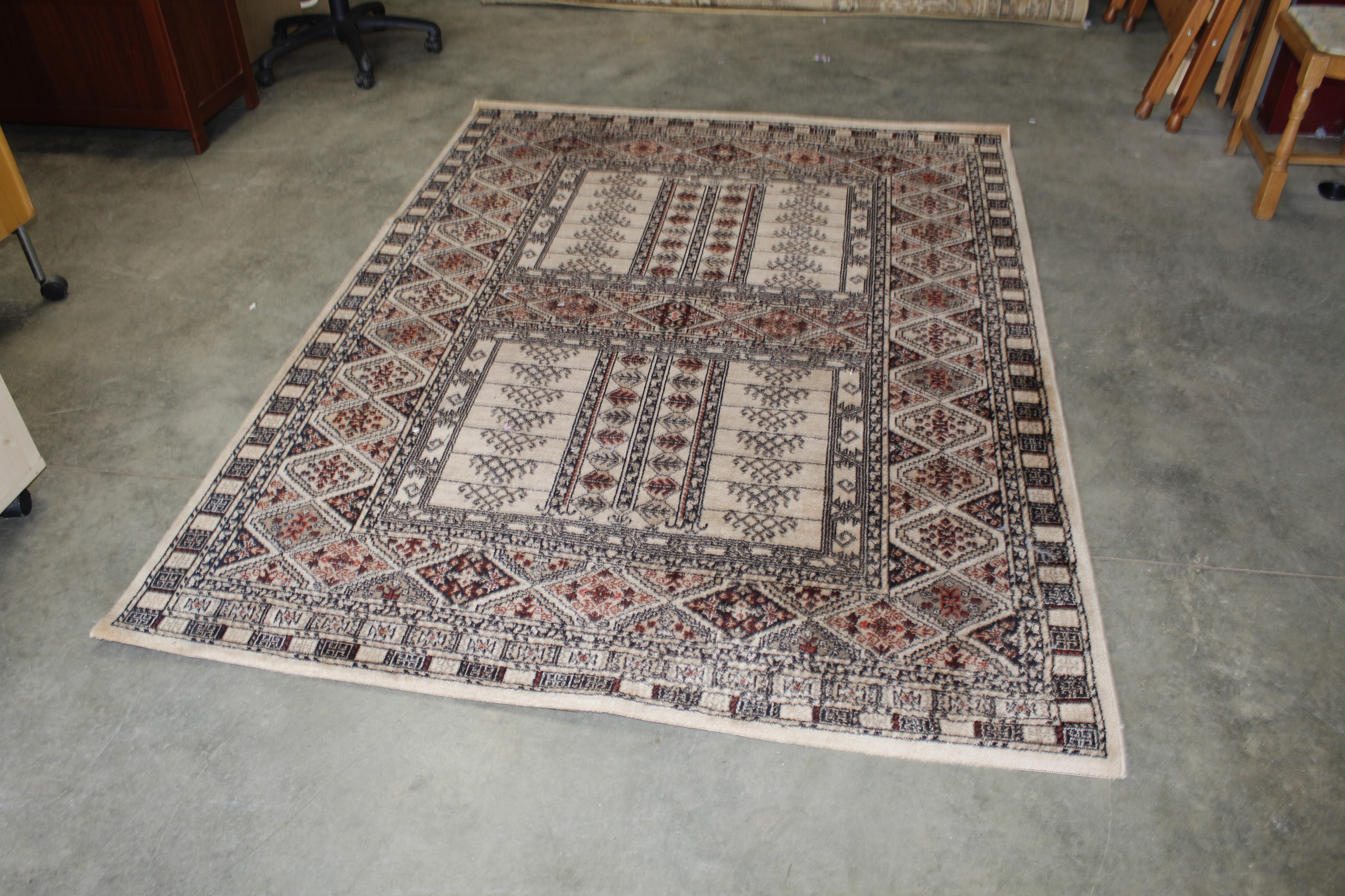 An approx. 7'6" x 5'7" beige patterned rug