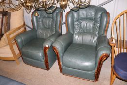 A pair of green leather upholstered armchairs