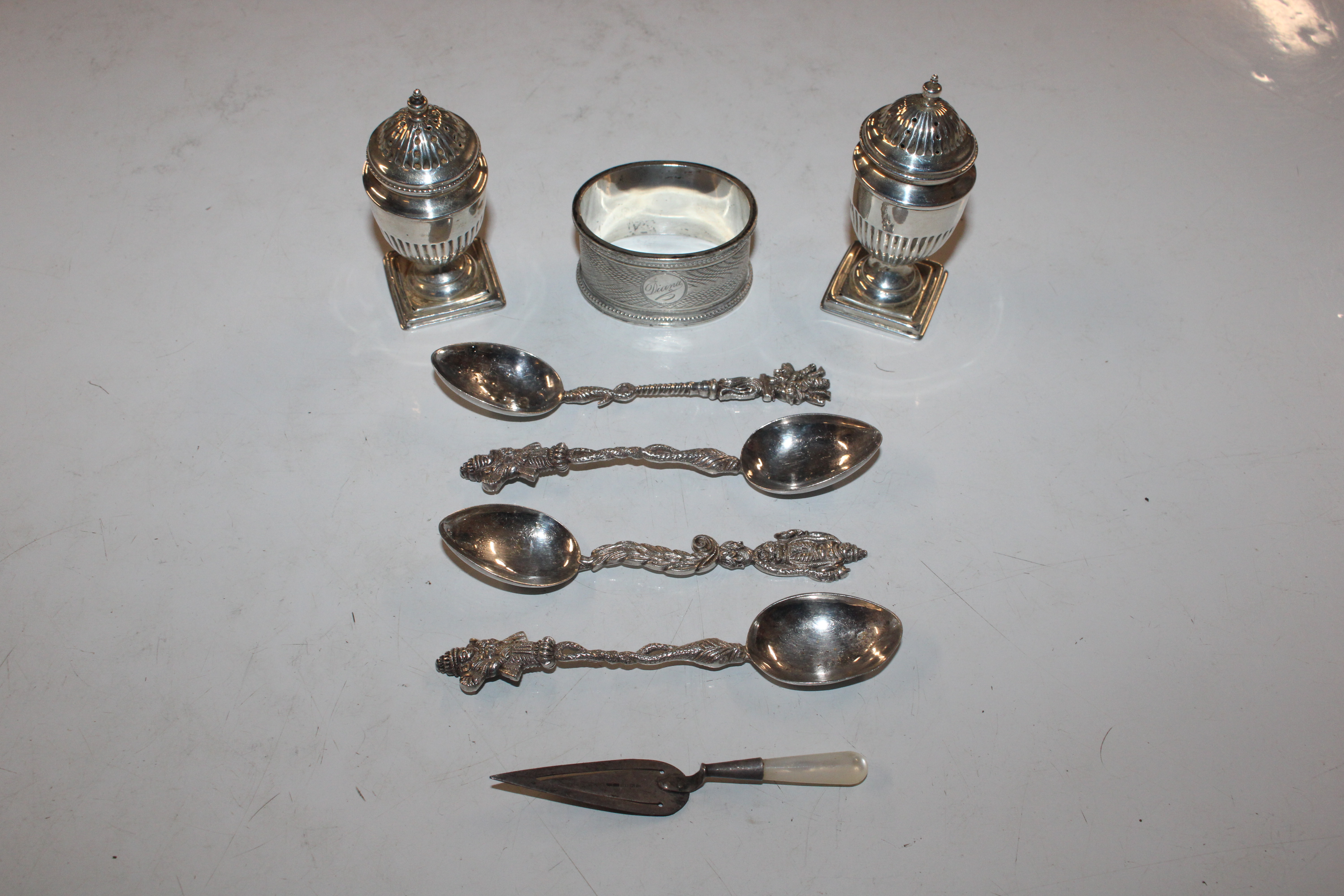 A pair of silver pepperettes; a silver napkin ring