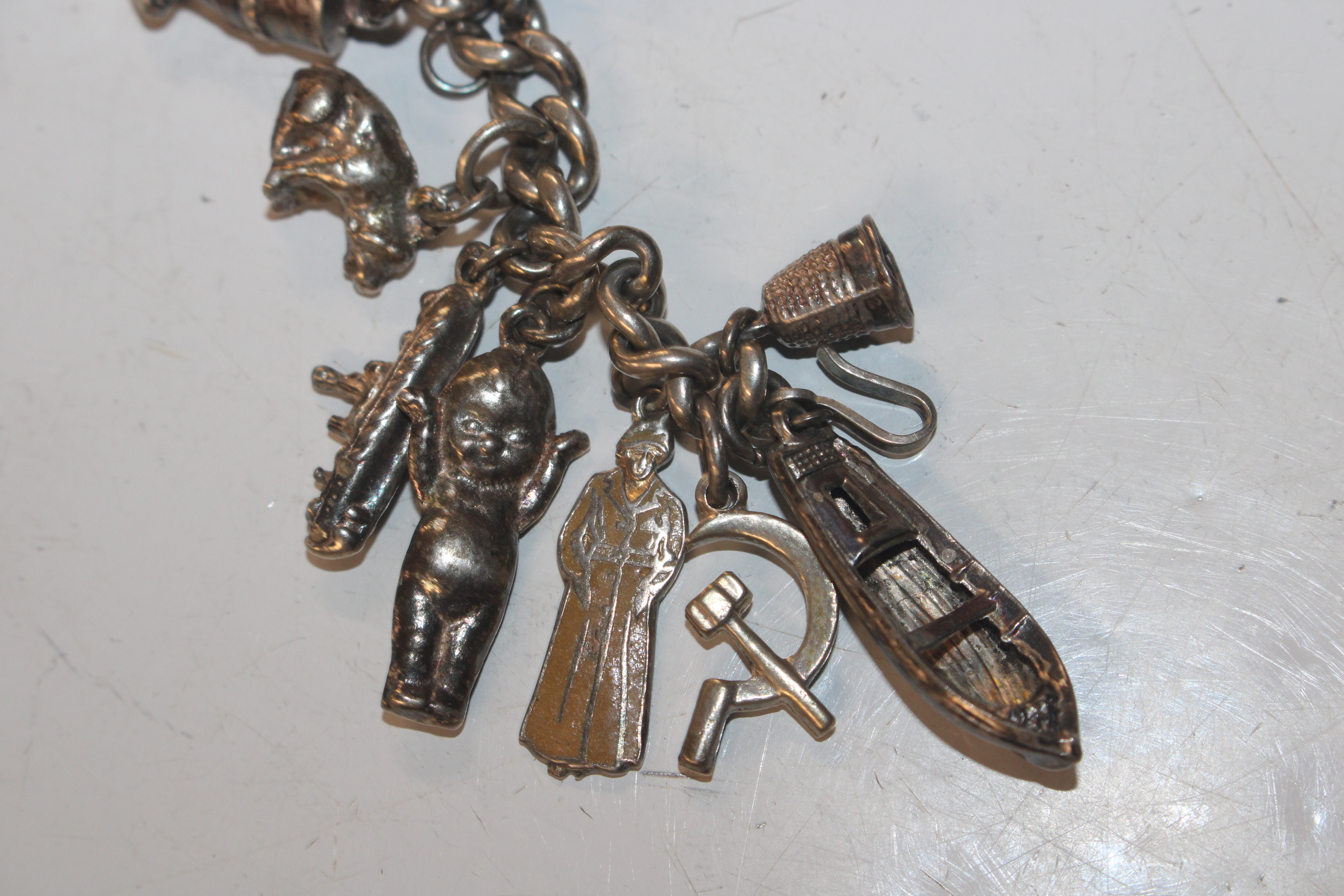 A silver charm bracelet with various silver and wh - Image 2 of 11