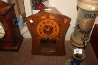 An Art Nouveau oak and inlaid wall clock of swept