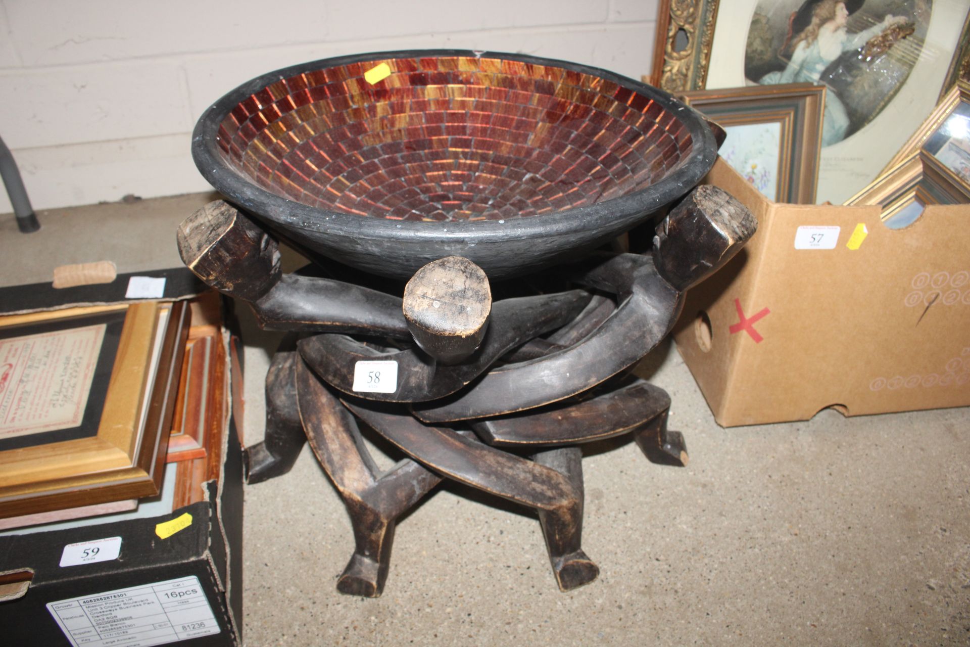 A decorative bowl on figural hardwood stand