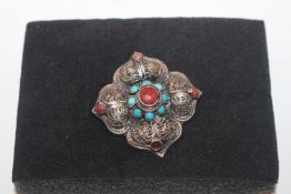 An antique silver turquoise and coral brooch