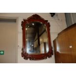 A red painted and gilt bevel edged wall mirror, me