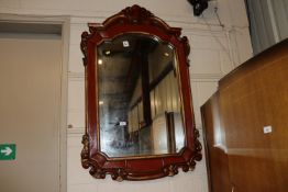A red painted and gilt bevel edged wall mirror, me