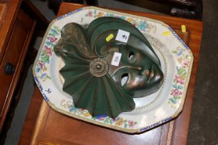 A decorative wall plaque in the form of a mask and