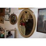 A gilt framed oval bevel edged wall mirror