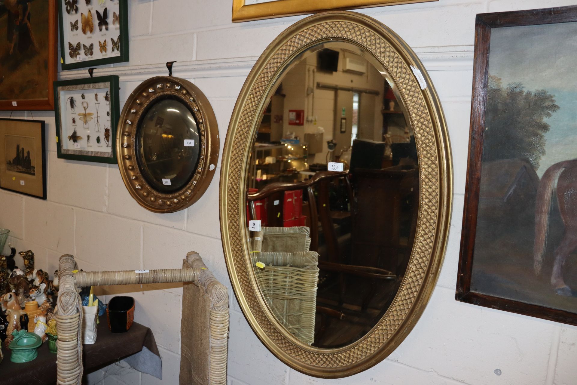 A gilt framed oval bevel edged wall mirror