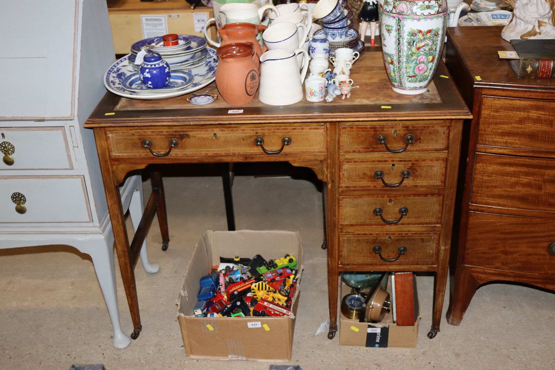 An Edwardian mahogany kneehole desk raised on squa