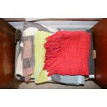 A box containing various rugs, blanket etc.