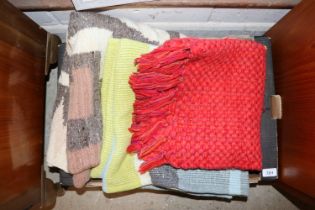 A box containing various rugs, blanket etc.