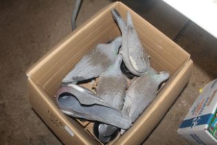 A box containing various decoy pigeons, clay pigeo