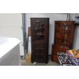 A carved oak floor standing corner display cabinet