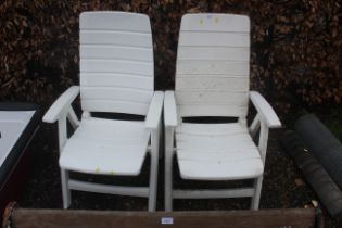 A pair of white plastic high back garden chairs