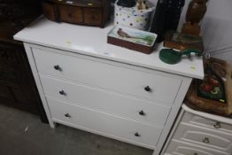 A modern white laminated chest of three long drawe