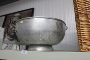 A large metal vintage colander