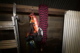 A climbing rope, shoes, harness and a bag