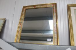 A gilt and floral decorated wall mirror