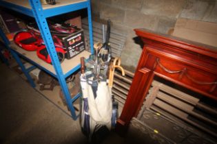 A vintage golf bag and quantity of clubs, an umbre