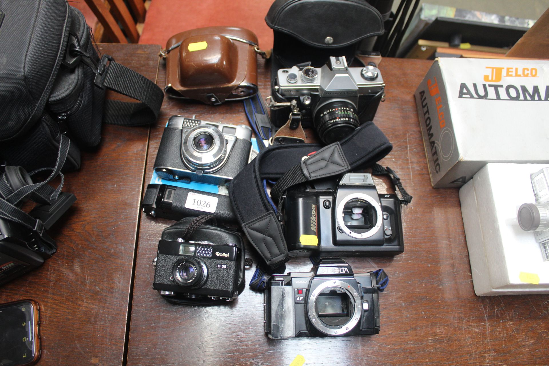 A Nikon camera body, a Minolta camera body, and va