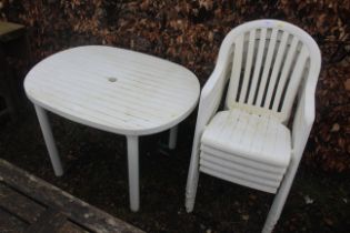 A white plastic garden table and set of five matching chairs