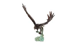 A bronze figure of an eagle with fish in it's claw, raised on a tree stump base, 46cm high