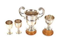 A small silver twin handled trophy and three smaller examples, 6oz