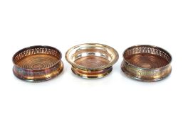 A pair of plated coasters, with pierced borders and turned wooden bases; and a single similar with
