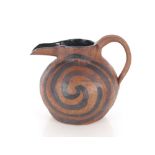 A brown and black glazed Studio pottery baluster water jug, of squat form with swirled decoration,