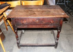 A late 17th Century oak side table fitted with single drawer and overhanging plank top, raised on
