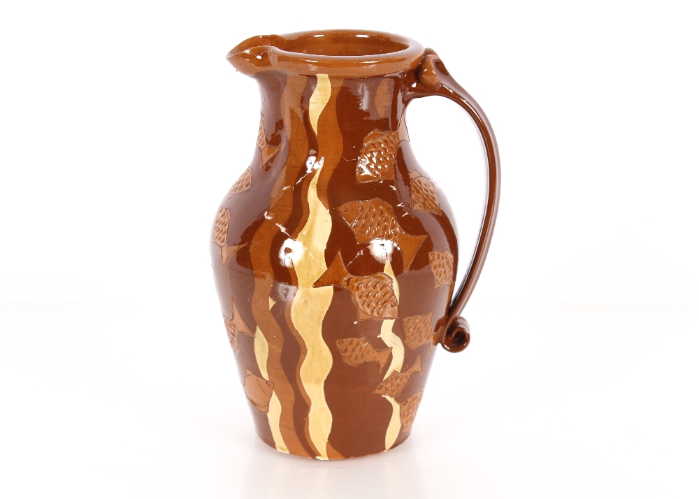 A brown glazed slipware type baluster water jug, with fish decoration, 32cm high