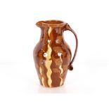 A brown glazed slipware type baluster water jug, with fish decoration, 32cm high