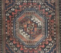 An Eastern rug of Caucasian design, the three central linked lozenge panels within stylised