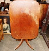 An early 19th Century mahogany tilt top occasional table, the rectangular top raised on a turned