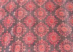 A large Afghan Bokhara rug traditional pattern, on brick red ground, approx. 10' x 13'