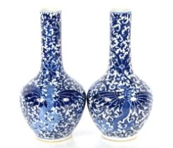 A pair of 19th Century Chinese blue and white bottle vases, having dragon and floral decoration,