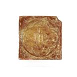 A Medieval period encaustic floor tile with inscription "I.H.S." 11.5cm sq.