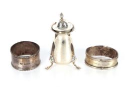 A silver pepperette, Birmingham 1907; and two silver napkin rings AF