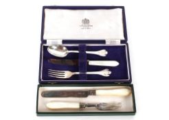 A modern silver cased three piece Christening set, the fork and spoon with trefid ends; and a mother
