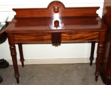 A 19th Century mahogany side table, having shallow raised back, two drawers below on turned tapering