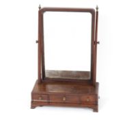 An 18th Century mahogany swing toilet mirror, the tapering arms surmounted by brass urn finials,